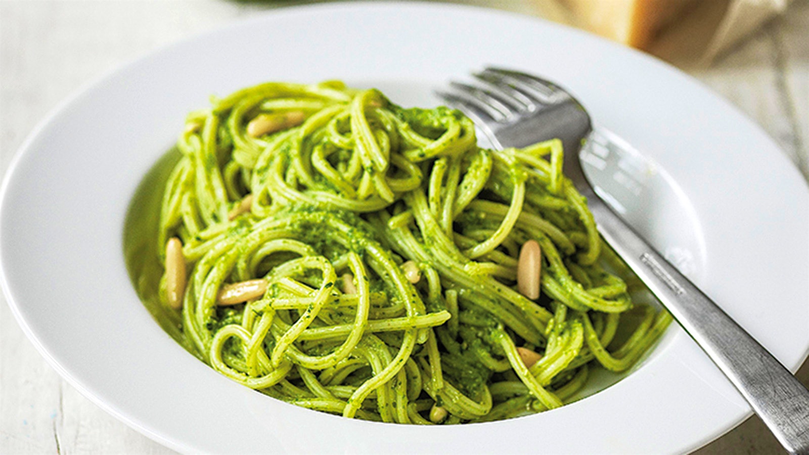 A plate of spaghetti with pesto